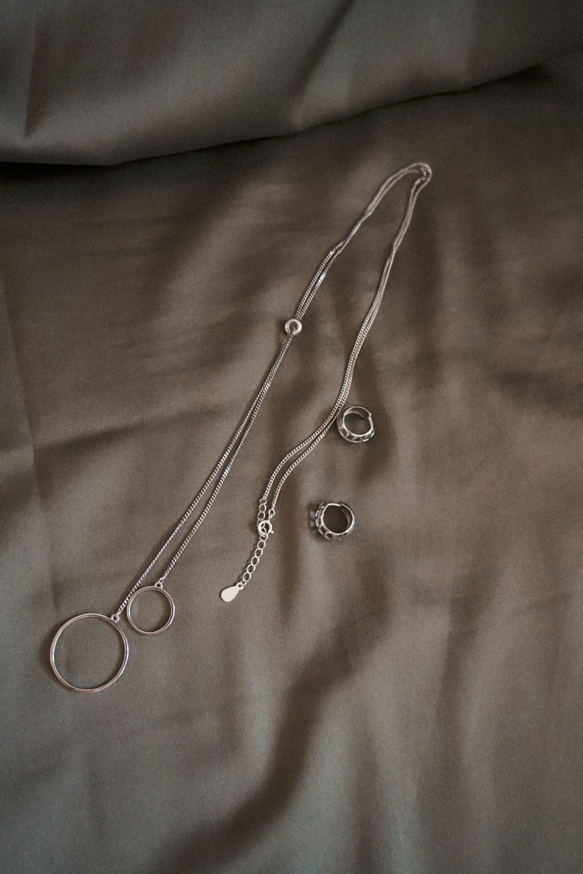 A fine silver chain laid on neutral linen